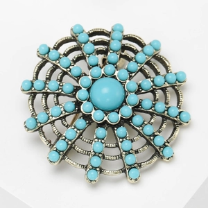 Vintage bohemian style sunburst brooch with blue rhinestones in antique gold finish