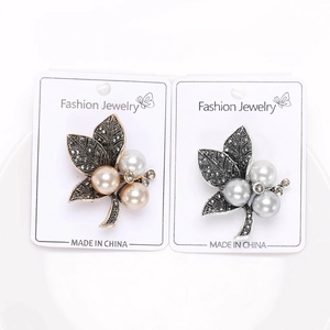 Detail of vintage leaf brooches with pearls and black rhinestones on display cards
