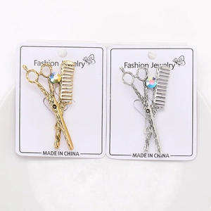 Detail view of scissors and comb brooches with rhinestones in gold and silver finish