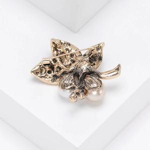 Detailed view of vintage bronze leaf brooch with pearls and secure pin closure mechanism