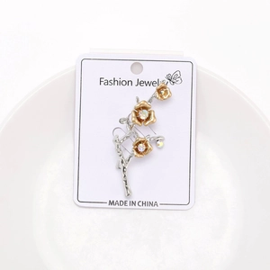 Detail of silver plum blossom branch brooch with golden flowers and sparkling rhinestones
