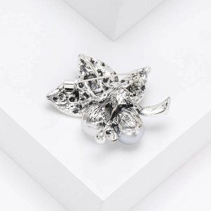 Detailed back view of vintage leaf brooch showing the secure safety pin and silver metal texture