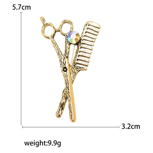 Vintage gold scissor and comb brooch for men's suits with dimensions 5.7cm x 3.2cm