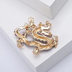 Detailed back view of golden enamel dragon brooch showing secure safety pin clasp