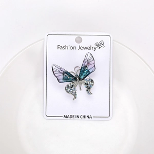 Detailed close-up of butterfly brooch with blue purple gradient wings and rhinestones