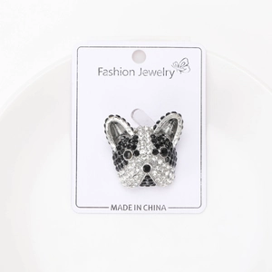 Detail shot of sparkling crystal bulldog brooch on a white decorative ceramic plate