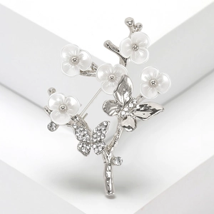 Broche élégante en branche d'argent avec papillons en strass et fleurs blanches