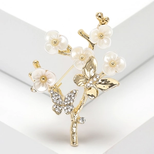Broche élégante fleur de prunier et papillon en strass doré sur fond blanc artistique