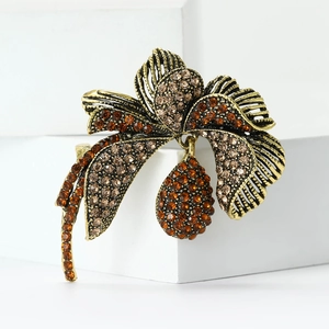 Close-up of vintage flower brooch with amber rhinestones on hollowed gold petals