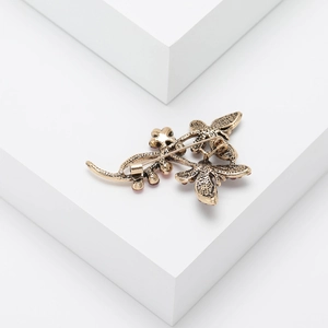 Macro detail of vintage gold butterfly brooch with rhinestones and safety pin clasp