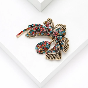 Detail view of vintage orchid brooch with multicolored rhinestones on antique gold alloy