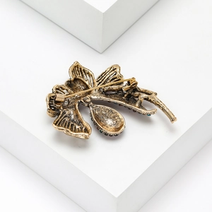 Detail view of the vintage gold alloy brooch back with secure pin and colorful crystals