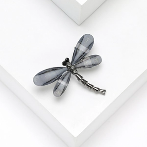 Spilla creativa a libellula con ali in acrilico grigio e accenti in cristallo lucido