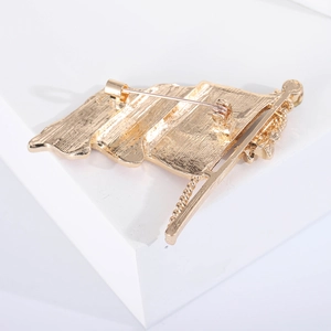 Detail view of the golden metal brooch back with secure pin clasp and textured finish