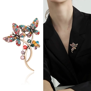 Vintage gold butterfly brooch with colorful crystals on a black suit lapel for women