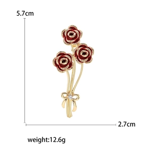 Elegante spilla bouquet di rose in smalto rosso con dettagli dorati e strass brillante