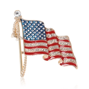 Enamel American flag brooch with rhinestones and golden tassels on a white background