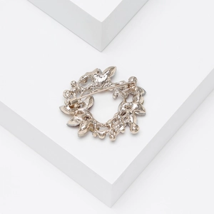 Macro shot of wreath-shaped brooch back showing silver pin and purple crystals