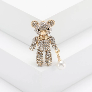 Sparkling rhinestone bear brooch with white pearl pendant on a white geometric stand