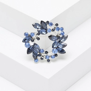 Elegant silver crystal wreath brooch with blue marquise cut stones and leaf design