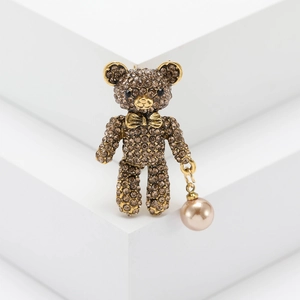 Vintage bear brooch with brown rhinestones and champagne pearl pendant on white steps