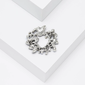 Detail of vintage silver wreath brooch with back safety pin and blue crystal inlay