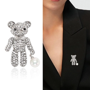 Broche ours mignonne en strass avec perle blanche sur fond blanc et portée sur un mannequin