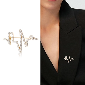 Élégante broche battement de cœur dorée avec strass blancs sur un revers noir chic