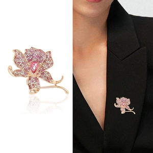 Luxury orchid flower brooch with pink zircons and pear-shaped stone on a black suit