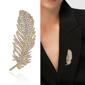 Elegante spilla a piuma dorata con strass scintillanti sul risvolto di una giacca