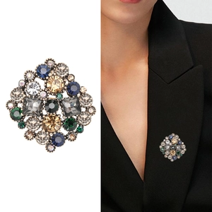 Vintage rhodium brooch with colorful rhinestones on a blazer and in a studio flat lay