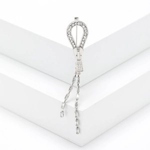 Broche fermeture éclair argentée avec strass et franges en zircon sur fond blanc