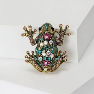 Exquisite Vintage Frosch Brosche in Goldoptik mit bunten Strasssteinen auf weißem Sockel