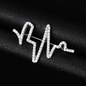 Gros plan d'une broche battement de cœur scintillante avec zircons sur cuir noir texturé