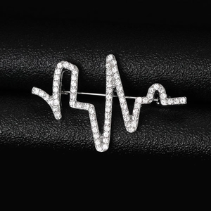 Vue détaillée de la broche électrocardiogramme argentée avec strass sur cuir noir