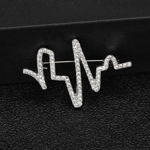 Détail macro de la broche ligne de battement de coeur avec placage argent et strass brillants
