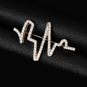 Vue macro d'une broche battement de coeur dorée avec strass sur cuir noir élégant