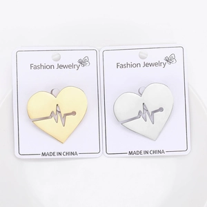 Detailed comparison of gold and silver EKG heart pins on white display cards