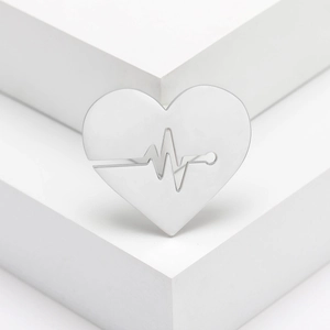 Minimalist silver heart brooch with electrocardiogram cutout on white display