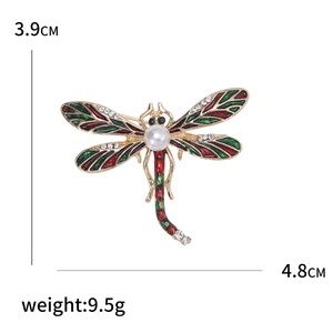 Broche libellule en émail avec base dorée, accents rouge vert et perle centrale