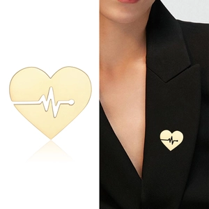 Minimalist gold heart brooch with heartbeat line design shown on white background and model
