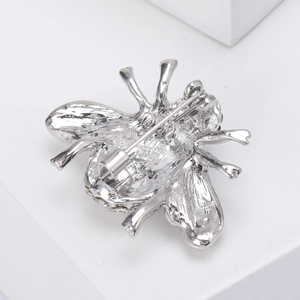 Detail view of the polished silver bee brooch back showing the pin clasp mechanism