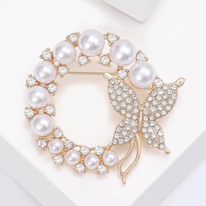 Detailed view of a gold-tone butterfly wreath brooch with pearls and sparkling rhinestones