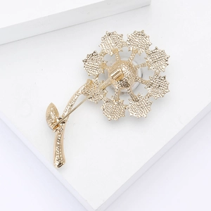 Close-up of golden dandelion brooch showing fine texture and secure rotating pin back