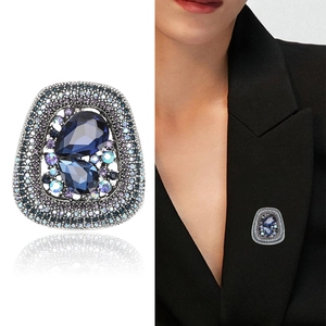 Vintage style brooch with blue crystals and colorful rhinestones on a black suit blazer