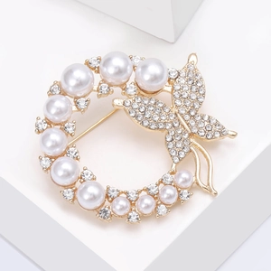 Detail of elegant butterfly pearl wreath brooch with sparkling rhinestones and gold plating