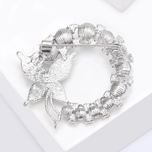 Detail view of the silver butterfly wreath brooch showing the secure back pin closure