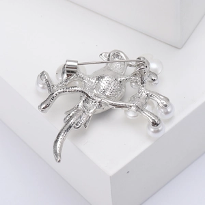 Macro view of the silver bird brooch back showing metal texture and safety pin clasp