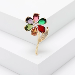 Detail of flower brooch featuring colorful pear-cut crystals and white pearl stamens