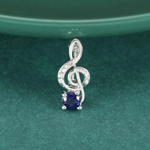 Eleganter Violinschlüssel-Brosche mit blauem Edelstein und funkelnden Kristallen